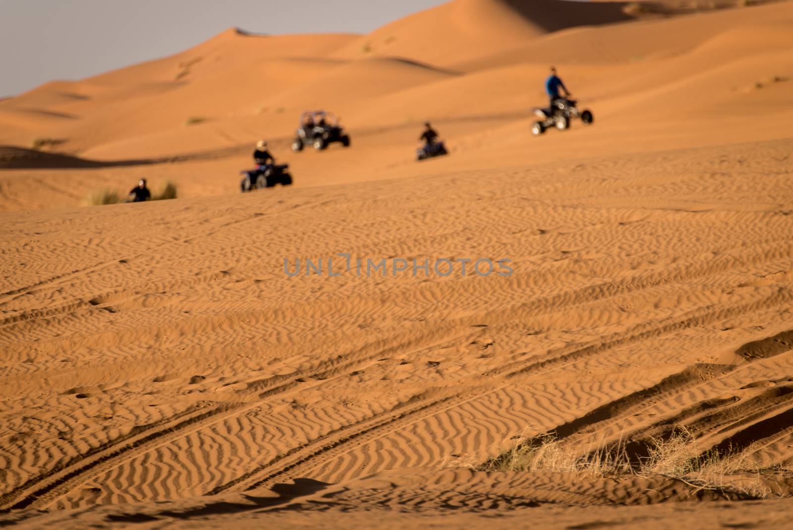 Quads and buggys riding through Sahara Desert dunes. Morroco.
