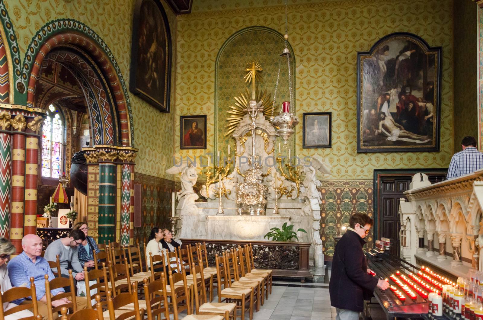 Bruges, Belgium - May 11, 2015: Tourists visit Interior of Basilica of the Holy Blood in Bruges, Belgium on May 11, 2015. Basilica is located in the Burg square and consists of a lower and upper chapel.