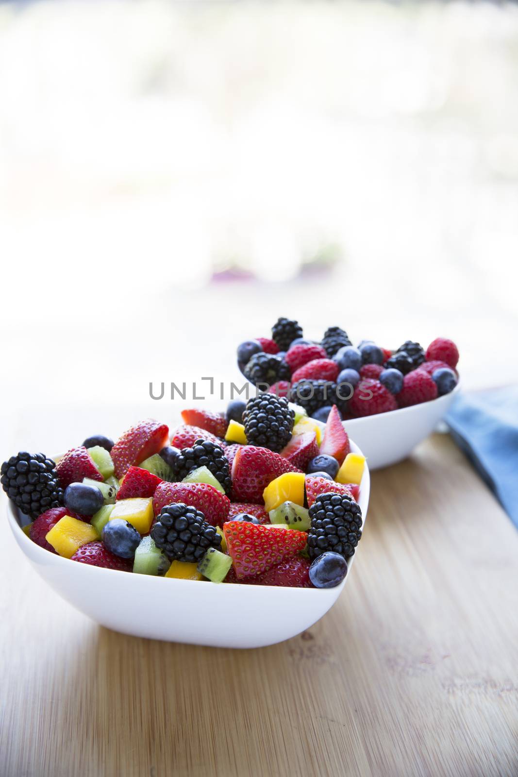 Healthy fresh fruit salad with strawberries, blackberries, mango, blueberries and kiwi.