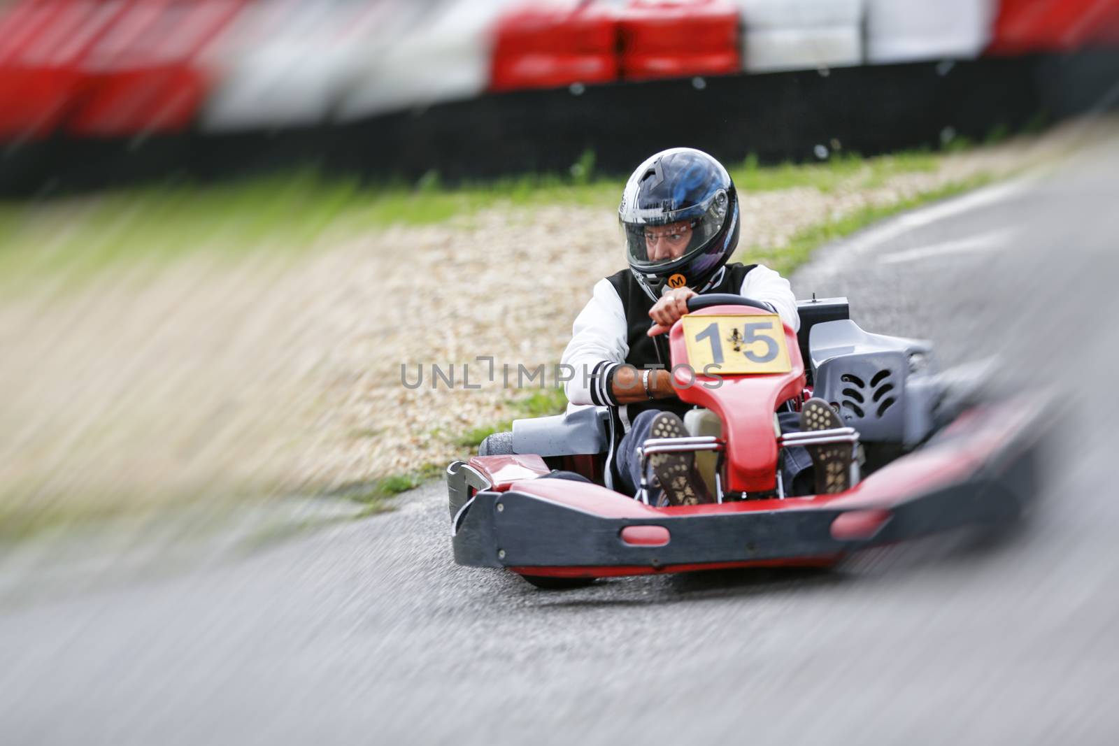 go-kart pilot is racing a race in an outdoor go karting circuit 