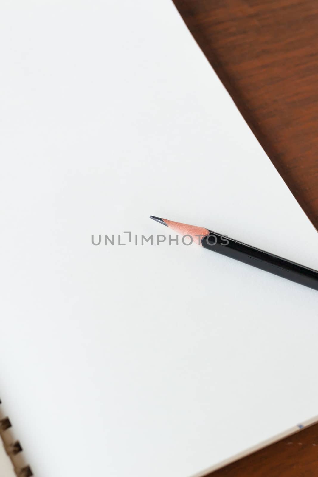 Blank note book with pencil on wooden table background concept and Idea for write your text here.