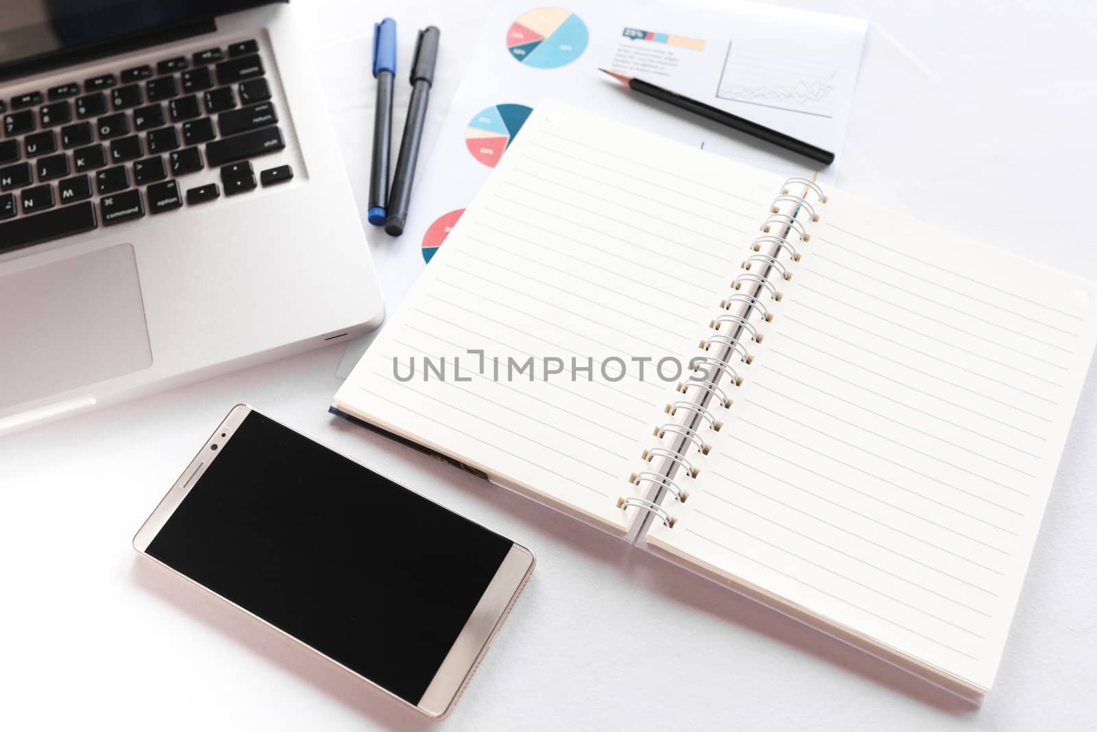 Blank note book with pencil pen laptop and smartphone on white table concept and Idea for write your text here.