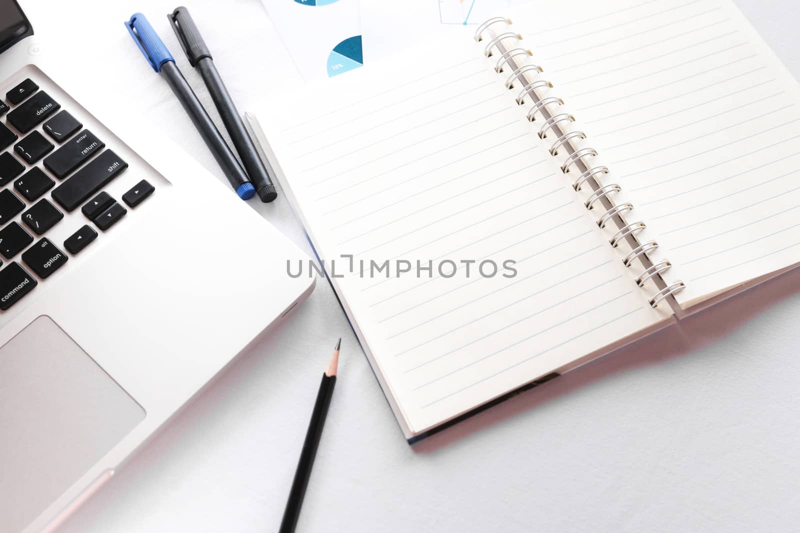 Blank note book with pencil pen and laptop on white table concept and Idea for write your text here.