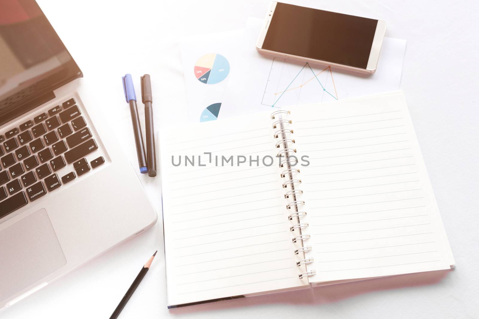 Blank note book with pencil pen laptop and smartphone on white table concept and Idea for write your text here.