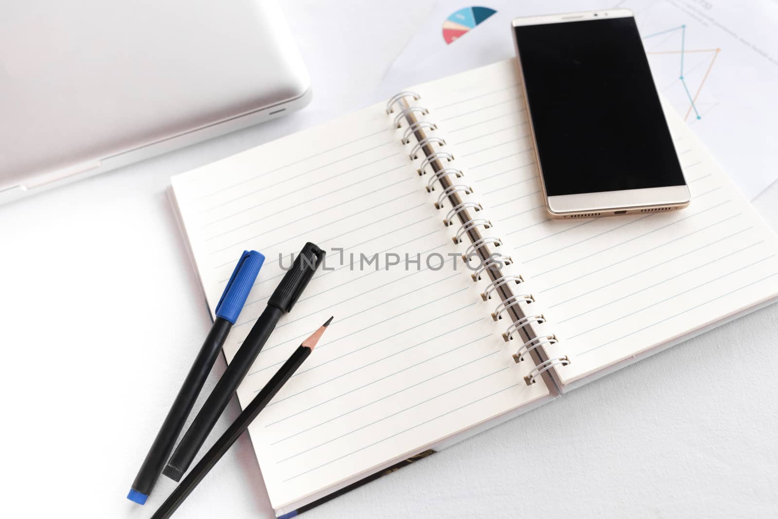 Blank note book with pencil pen laptop and smartphone on white table concept and Idea for write your text here.