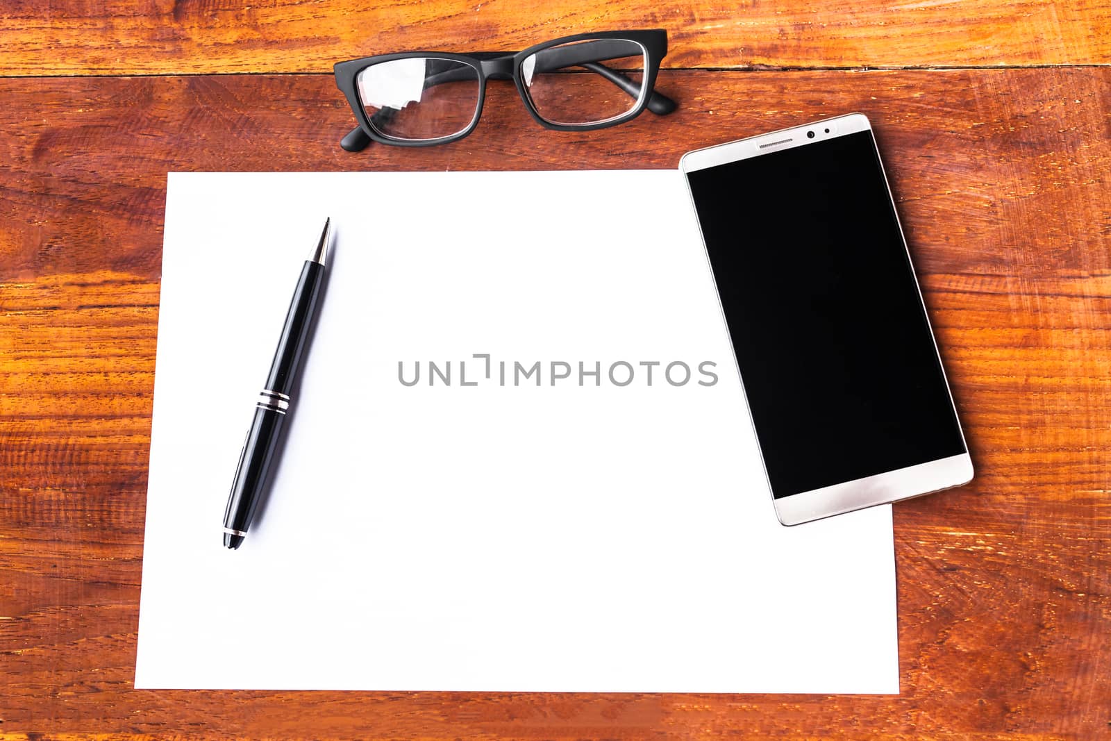 Blank paper with pen and smartphone on wood table concept and Id by nopparats