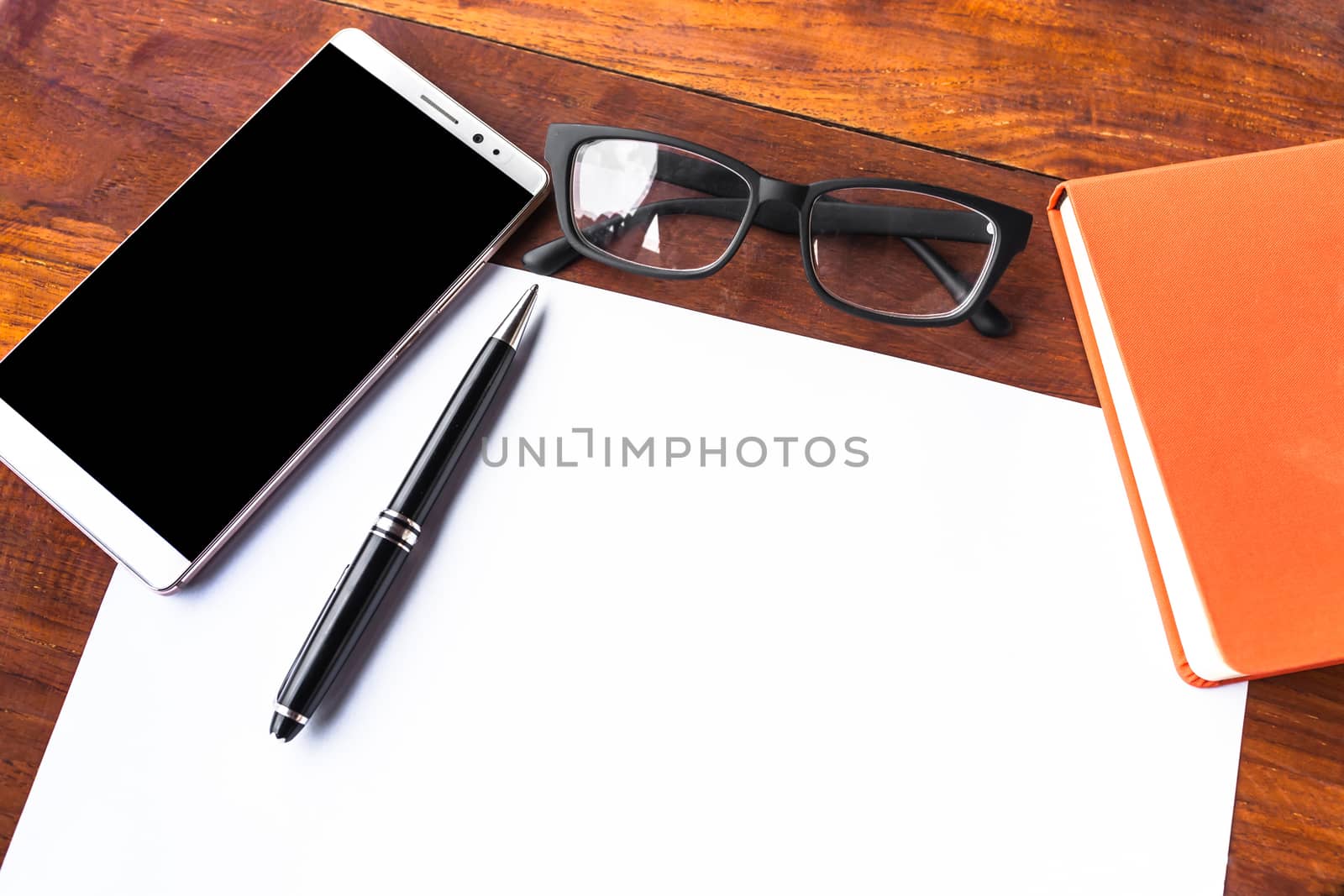 Blank paper with pen and smartphone on wood table concept and Id by nopparats