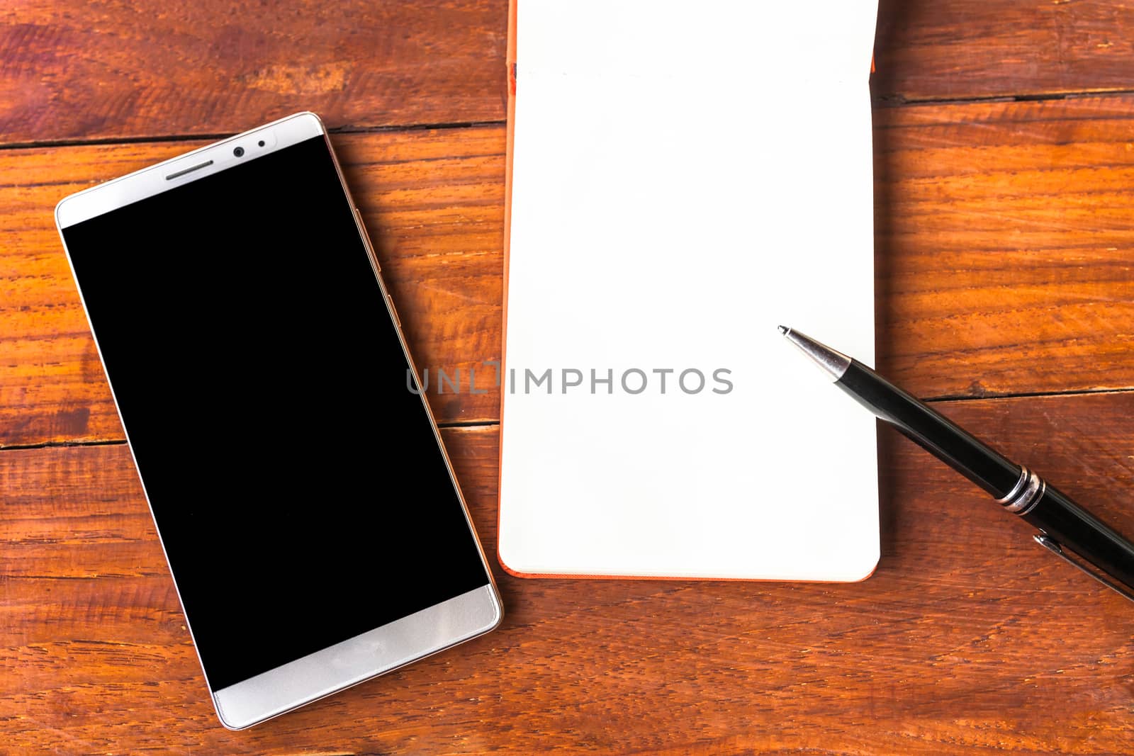 Blank paper with pen and smartphone on wood table concept and Idea for write your text here.