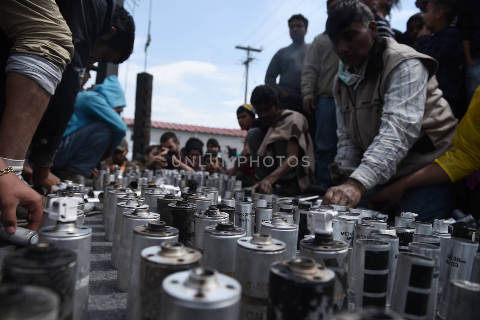 GREECE, Idomeni: Migrants collect tear gas canisters on April 11, 2016 that were used against them by Macedonian security forces the day prior as they attempted to cross the border.Hundreds of migrants were injured on Sunday as they attempted to cross the border into Macedonia. Police used tear gas, water cannons, and stun grenades to disperse the crowd as migrants threw stones in retaliation. 