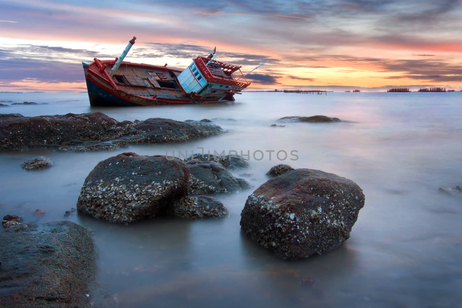 shipwreck stranded on the beach at sunset