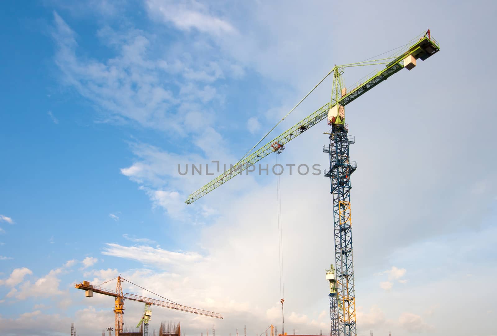 Industrial construction cranes on sky background