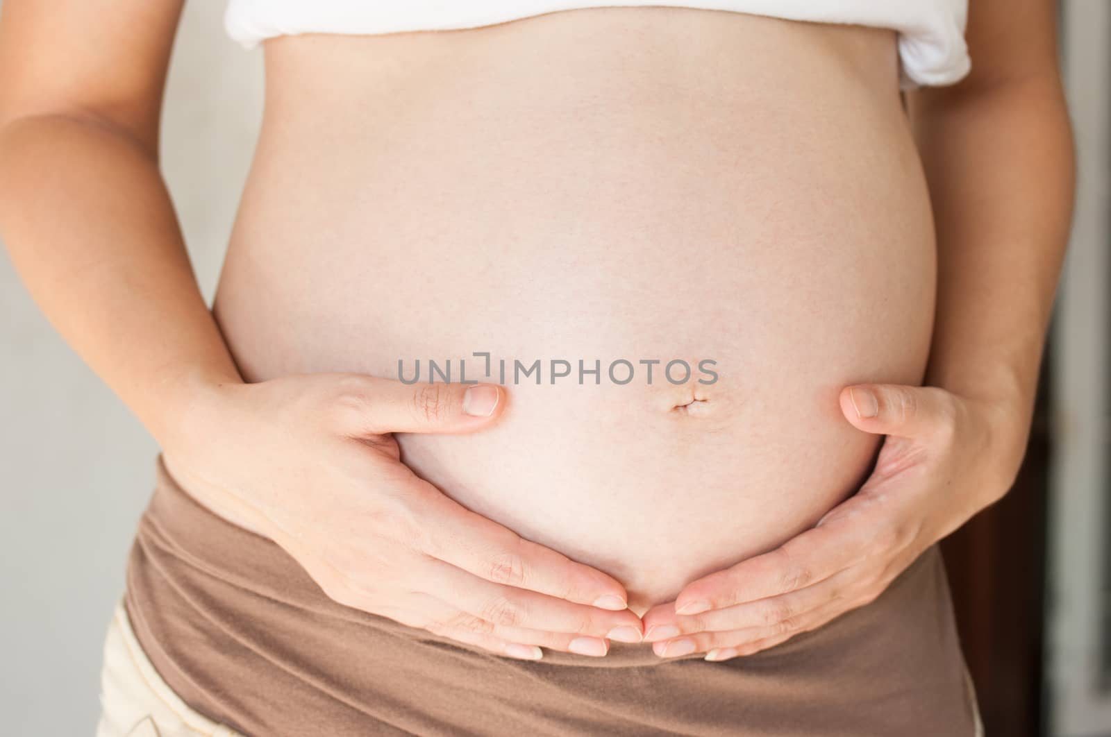 Pregnant woman holding her hand on belly