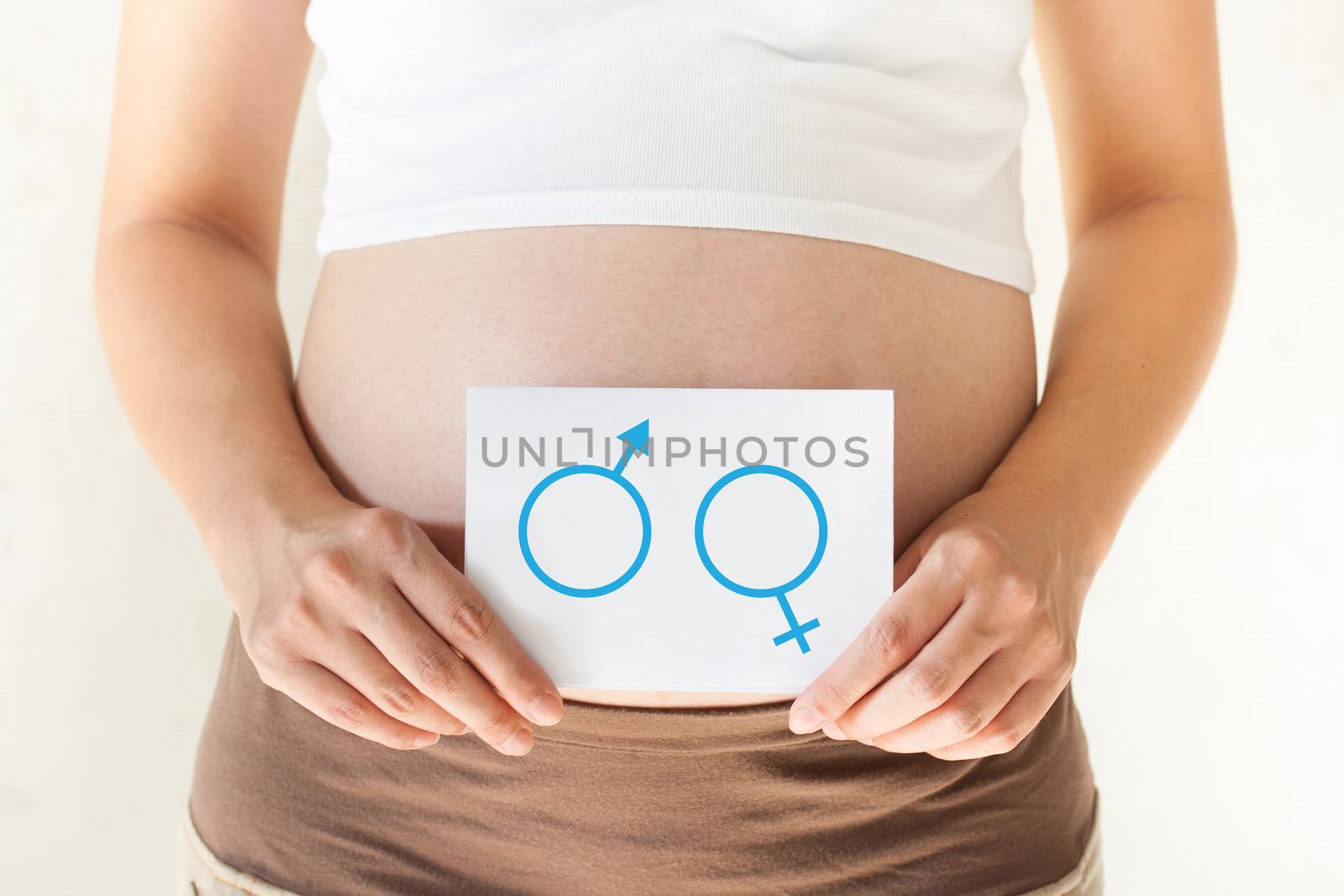 Pregnant woman holding her hands on the belly and holding a pape by pkproject