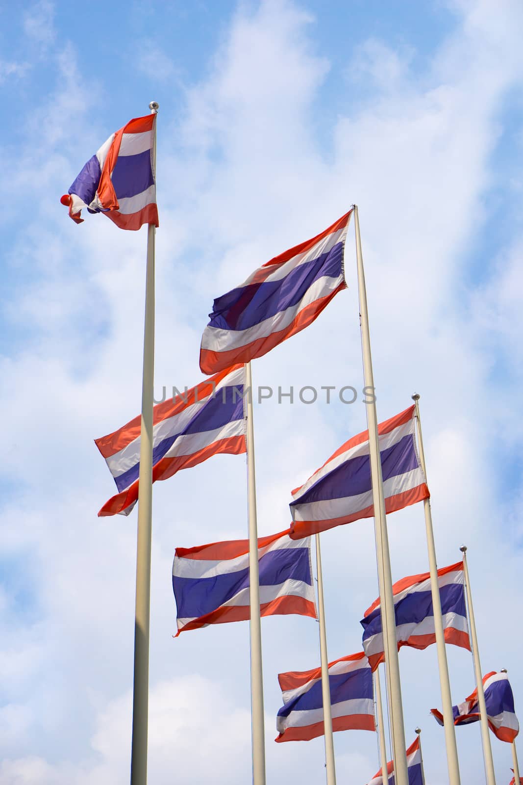 waving Thai flag of Thailand with blue sky background