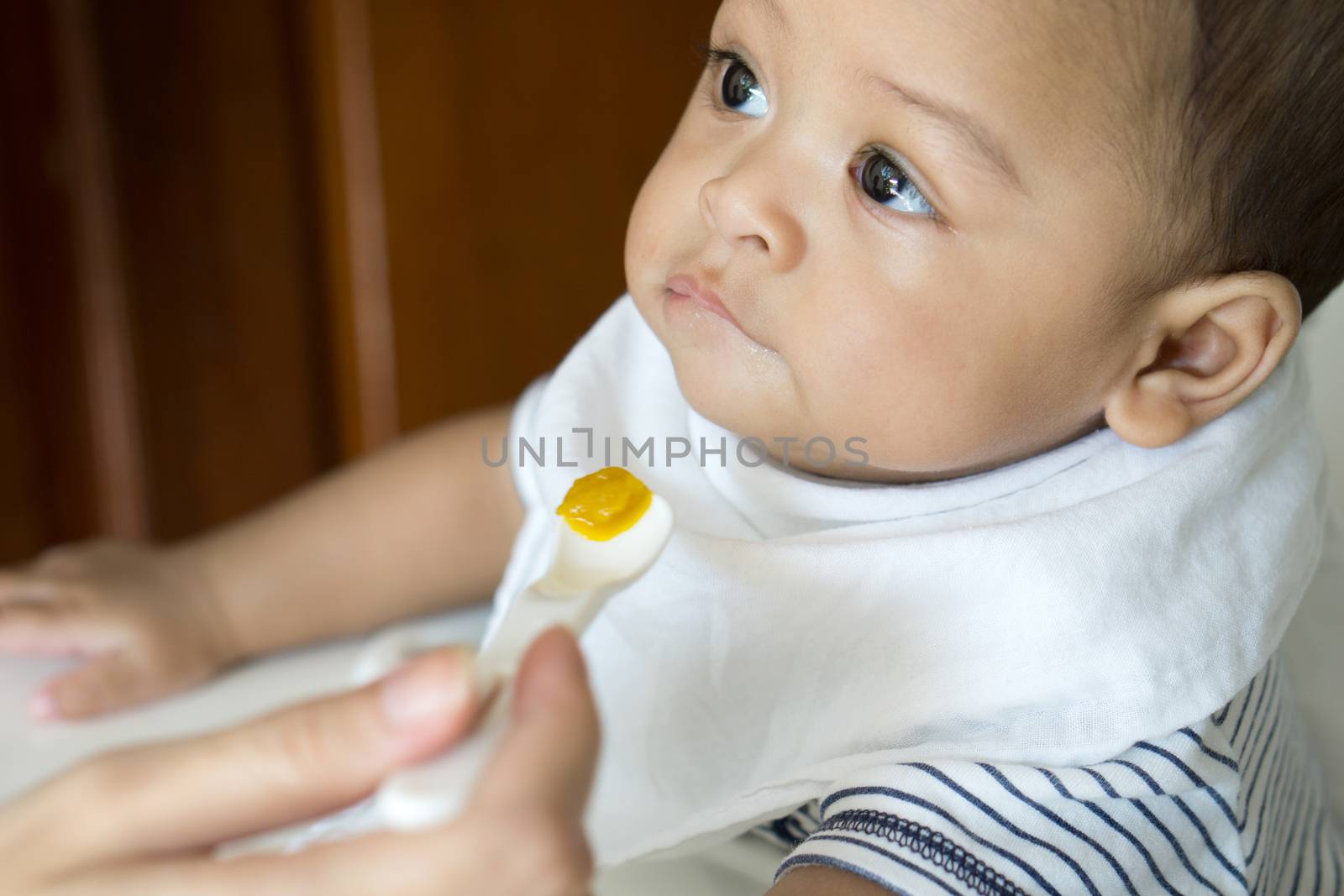 Eating from spoon of six month asian baby by pkproject