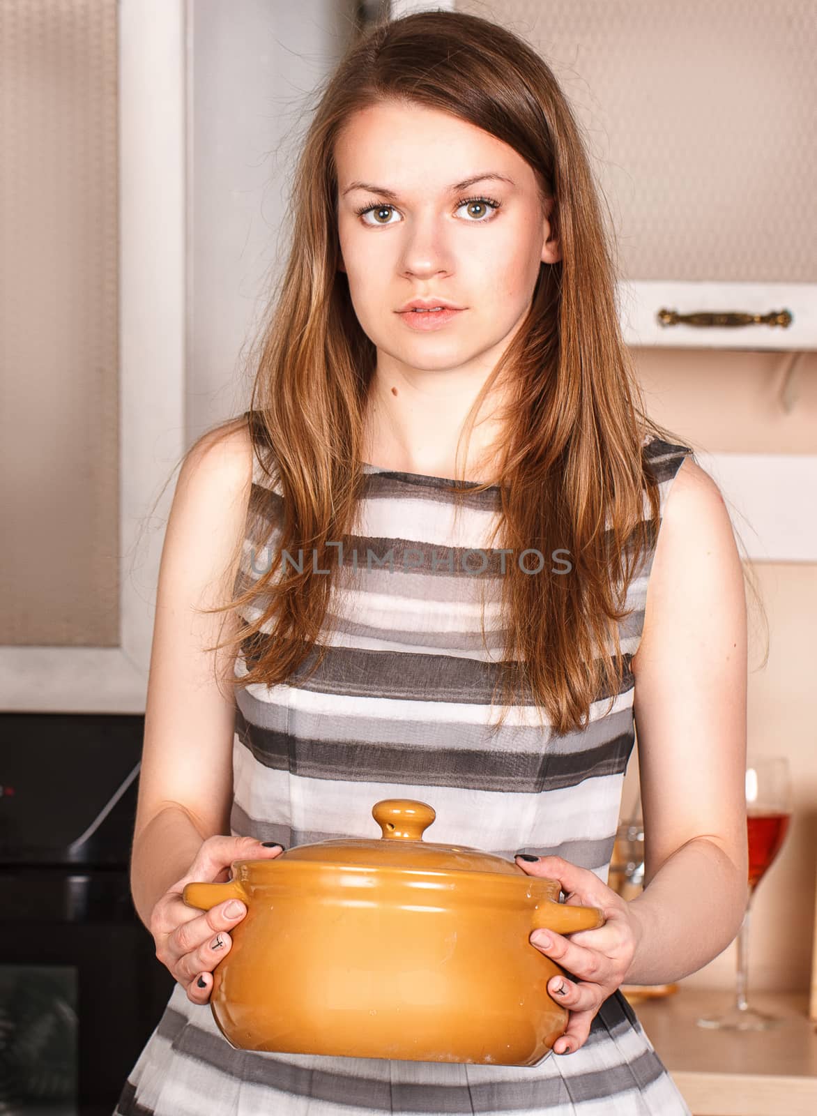 Beautiful woman chef offering a pot with hot food, ready to be eaten