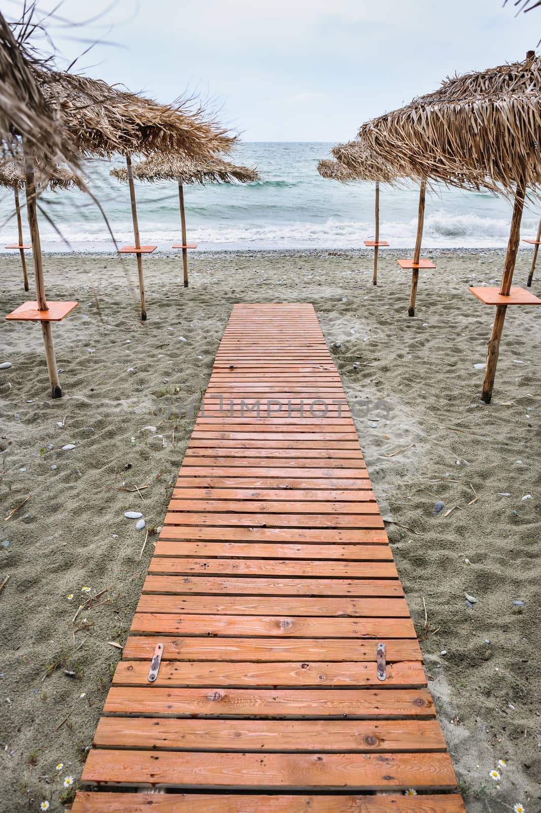 Wooden floor at the beach and dramatic overcast sky background