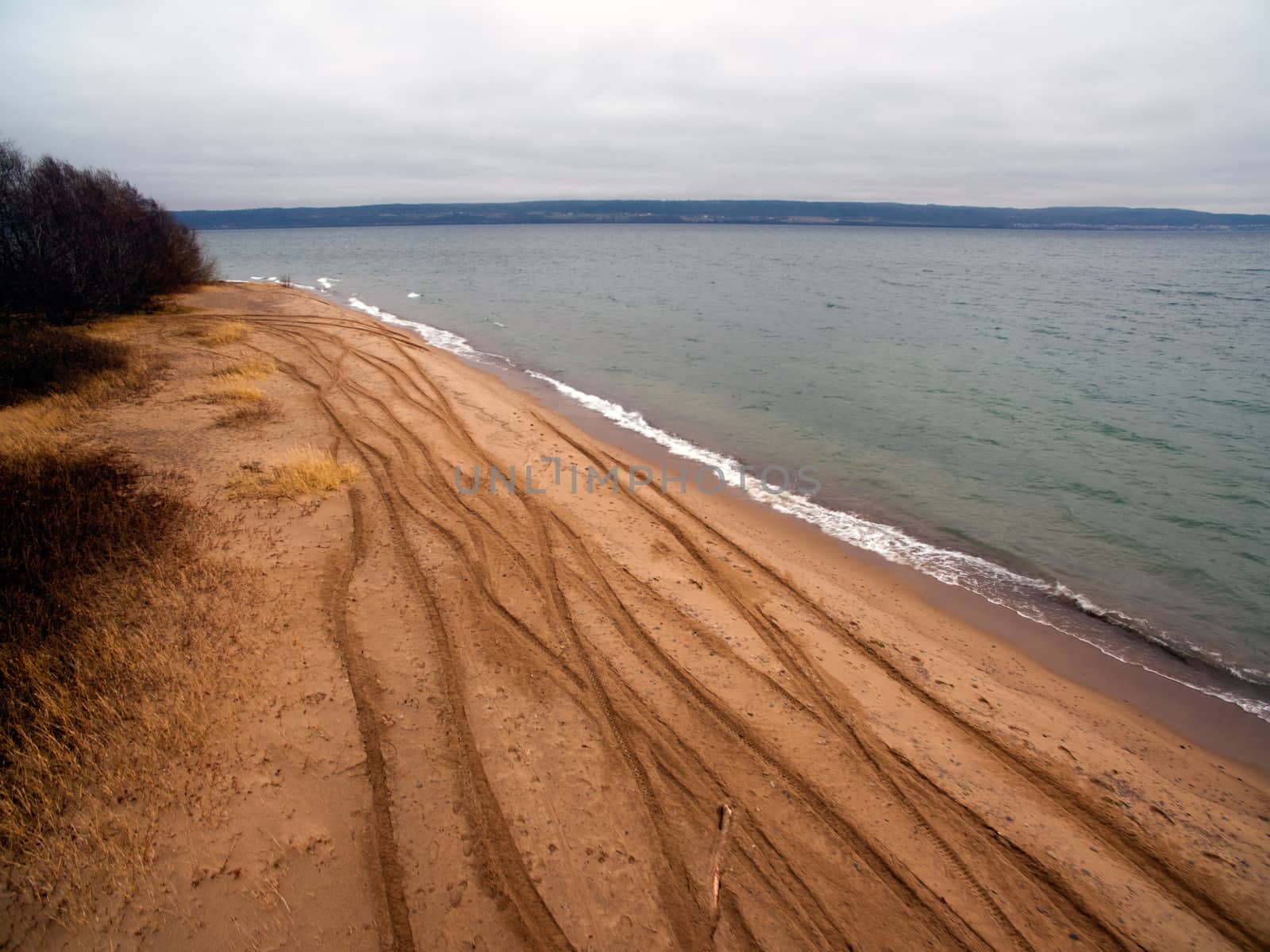 Sandy beach with dirt bike tracks