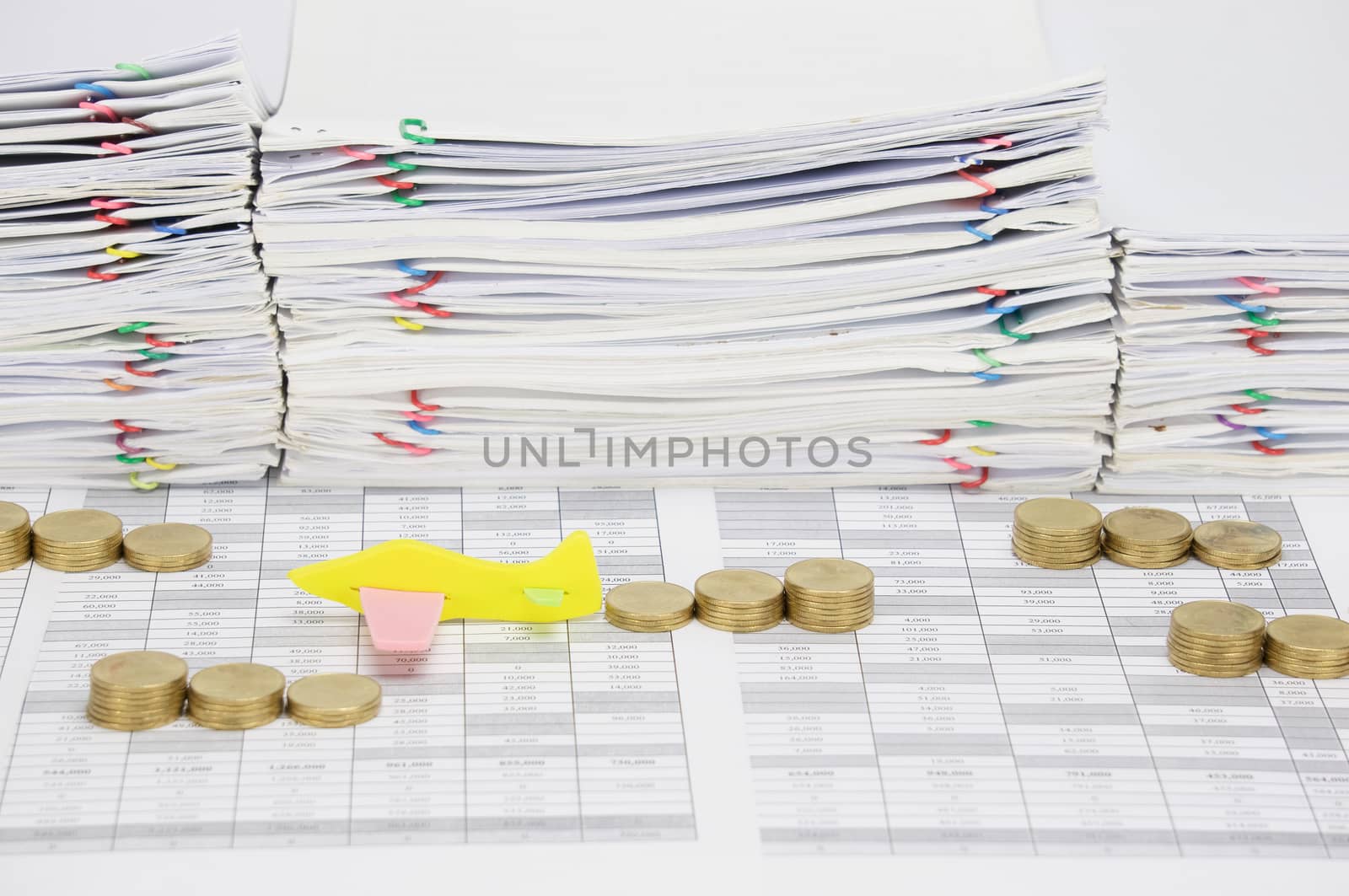 Airplane among step pile of gold coins on finance account have overload of paperwork with colorful paperclip as background.