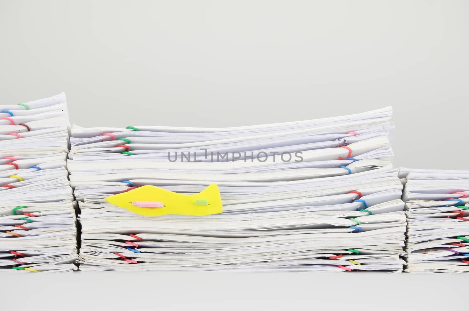 Airplane fly have stack overload document of receipt and report with colorful paperclip as background.