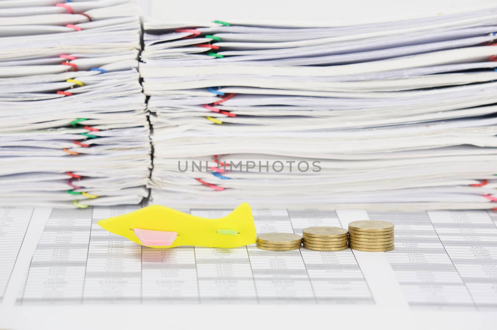 Airplane and step pile of gold coins on finance account have overload of paperwork with colorful paperclip as background.