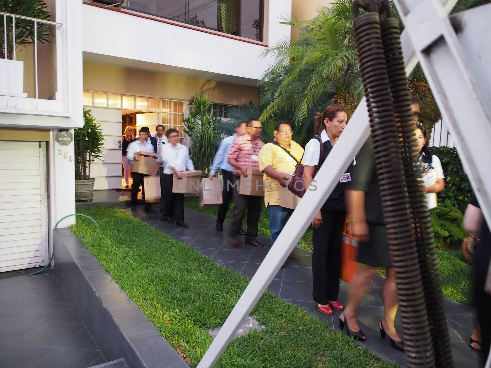 PERU, Lima : Tax authorities retrieve documents from the Mossack Fonseca offices escorted by police during a raid in Lima on April 11, 2016.Peruvian authorities raided a branch of Mossack Fonseca in Lima, which is located directly across the road from the Panamanian embassy. They said they were looking for evidence Peruvians used the firm for tax avoidance.