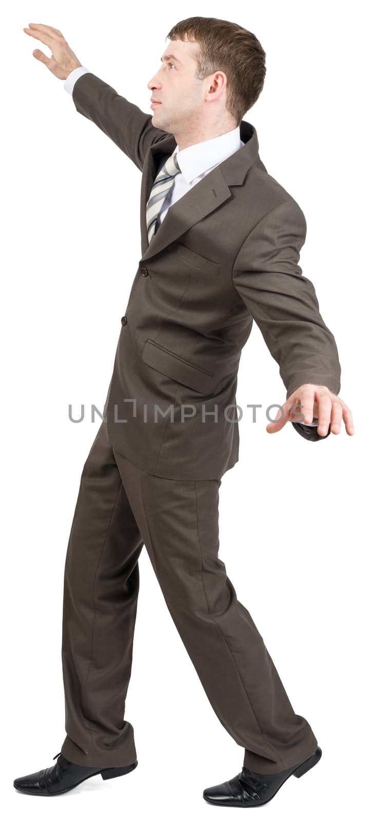 Businessman standing on tiptoes isolated on white background