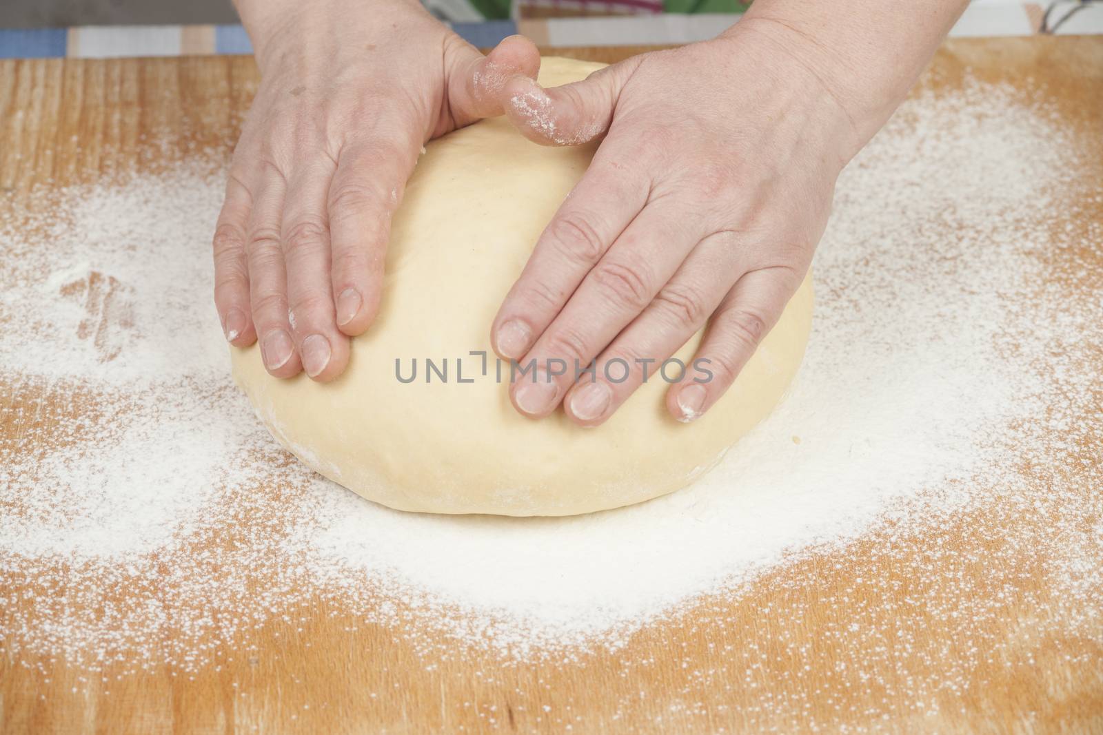 Ball of pizza dough with flour on the wooden table