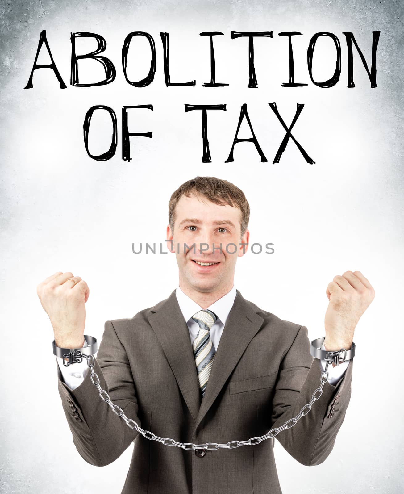 Happy businessman in cuffs with abolition of tax on grey wall background