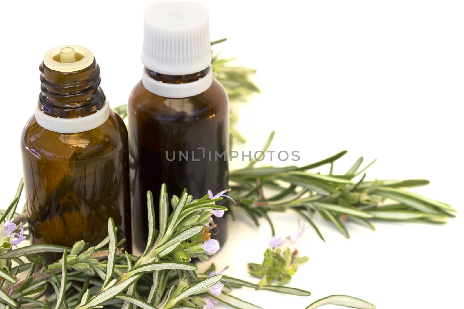 Essential aroma oil with rosemary on white background. Selective focus.