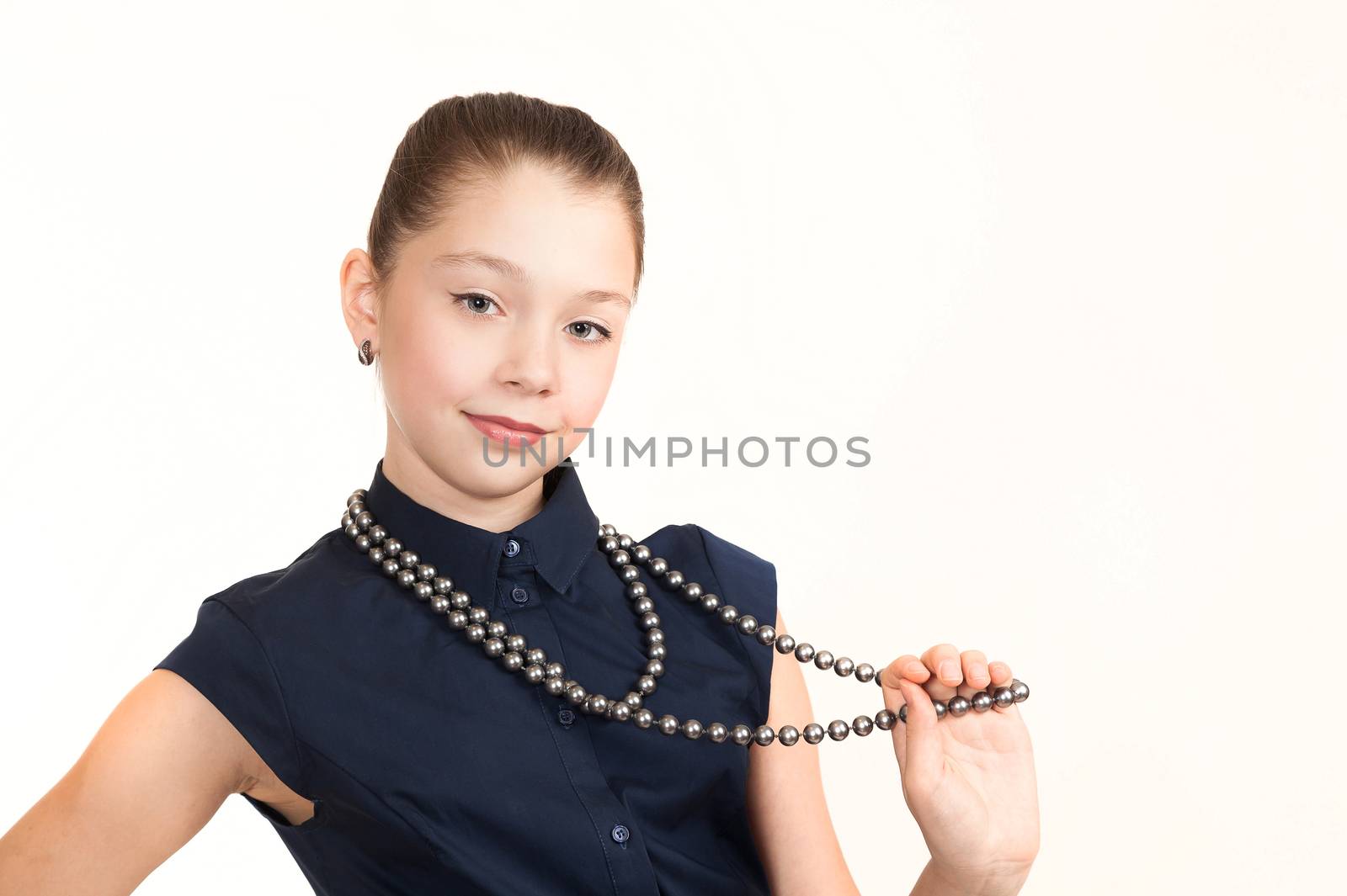 Portrait of the girl of the teenager in a suit with a beads on a white background