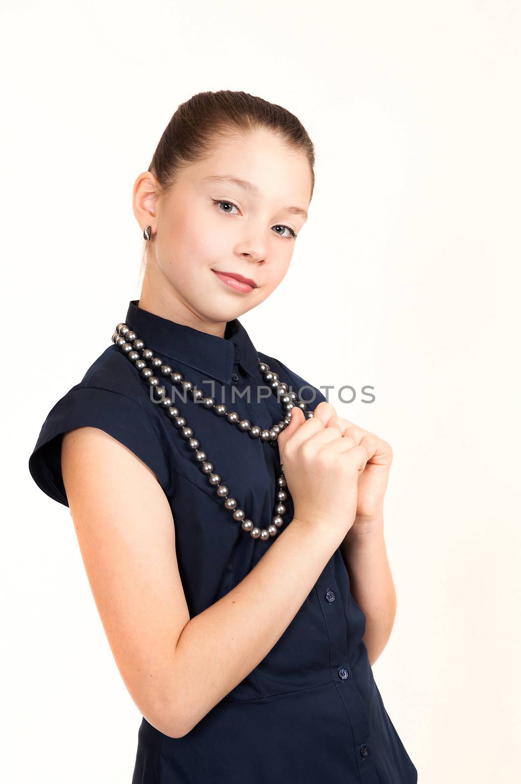 Portrait of the girl of the teenager in a suit with a beads on a white background