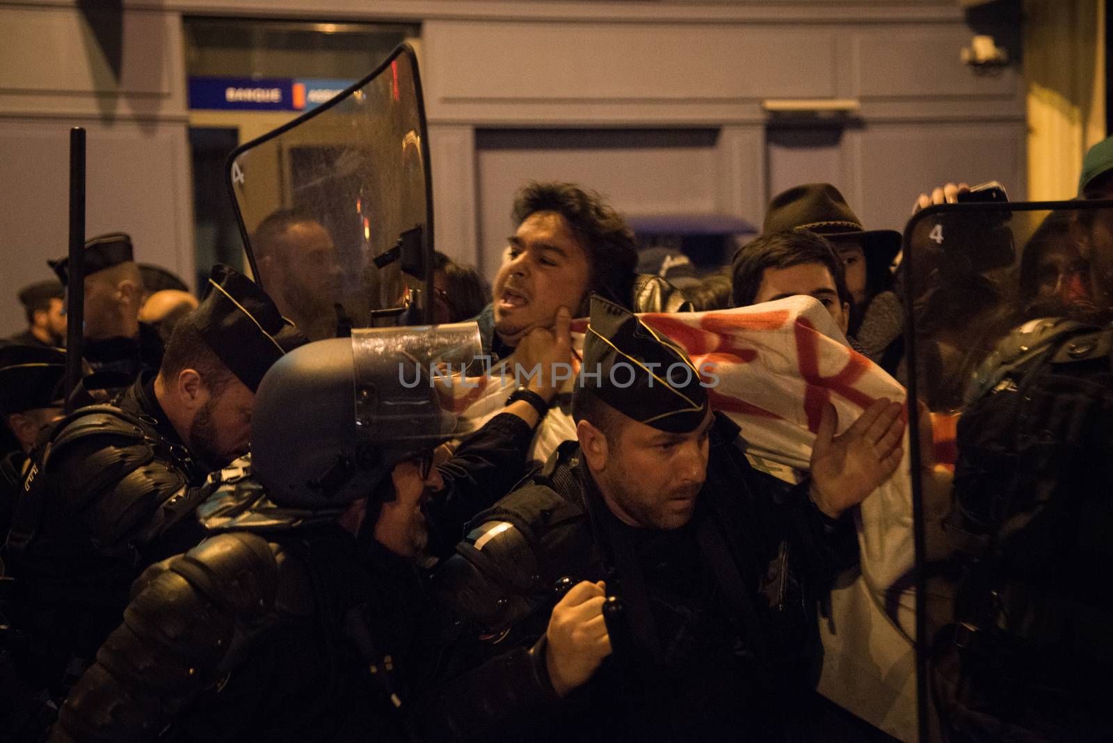 FRANCE, Paris: French police officers face protesters during a night demonstration in front of a police station in the 2nd arrondissement of Paris, on April 12, 2016. Protesters claim the release of a student arrested earlier in the day. 