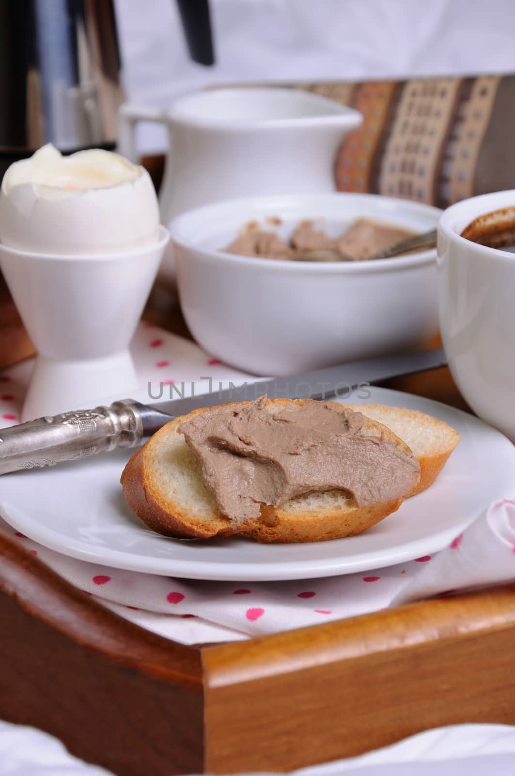 A slice of toast spread with liver pate for breakfast  on a tray