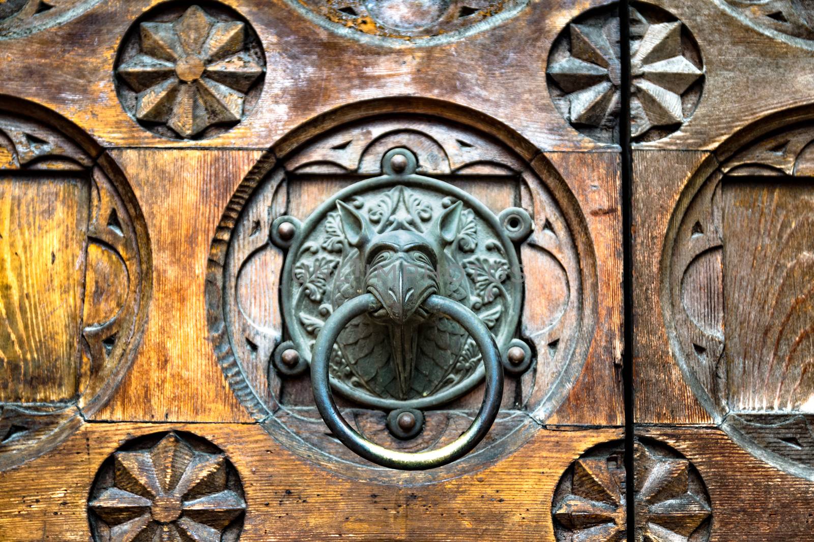 Antique door knocker shaped like monster's head.