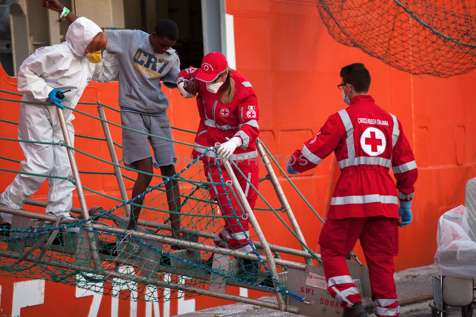 ITALY, Palermo: Medical workers assist a migrant off the Siem Pilot on April 13, 2016 in Palermo, Italy.The vessel has been a major transporter of migrants fleeing the Middle East and Africa to Europe. 