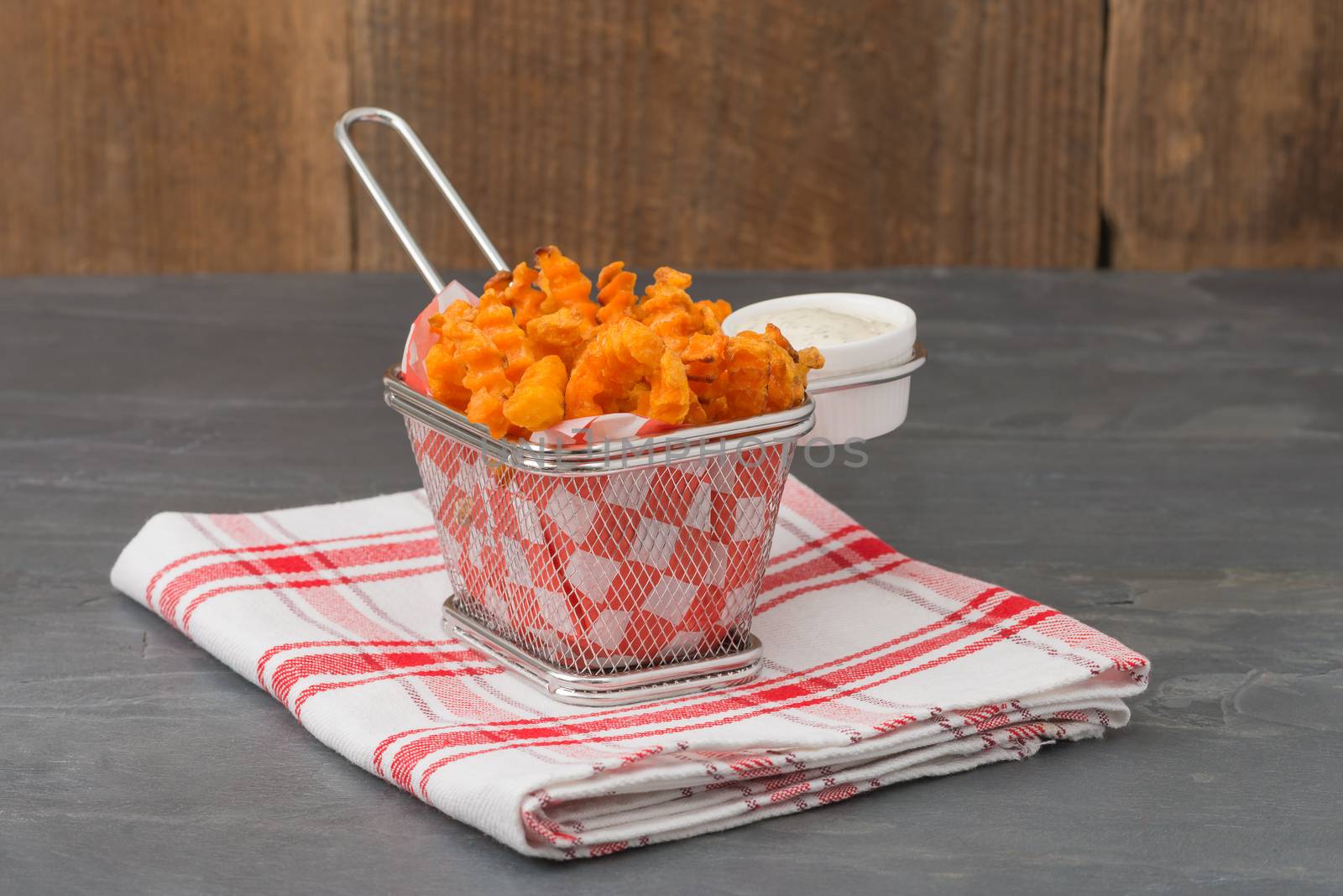 Basket of deep fried sweet potatoes with a buttermilk dill dipping sauce.