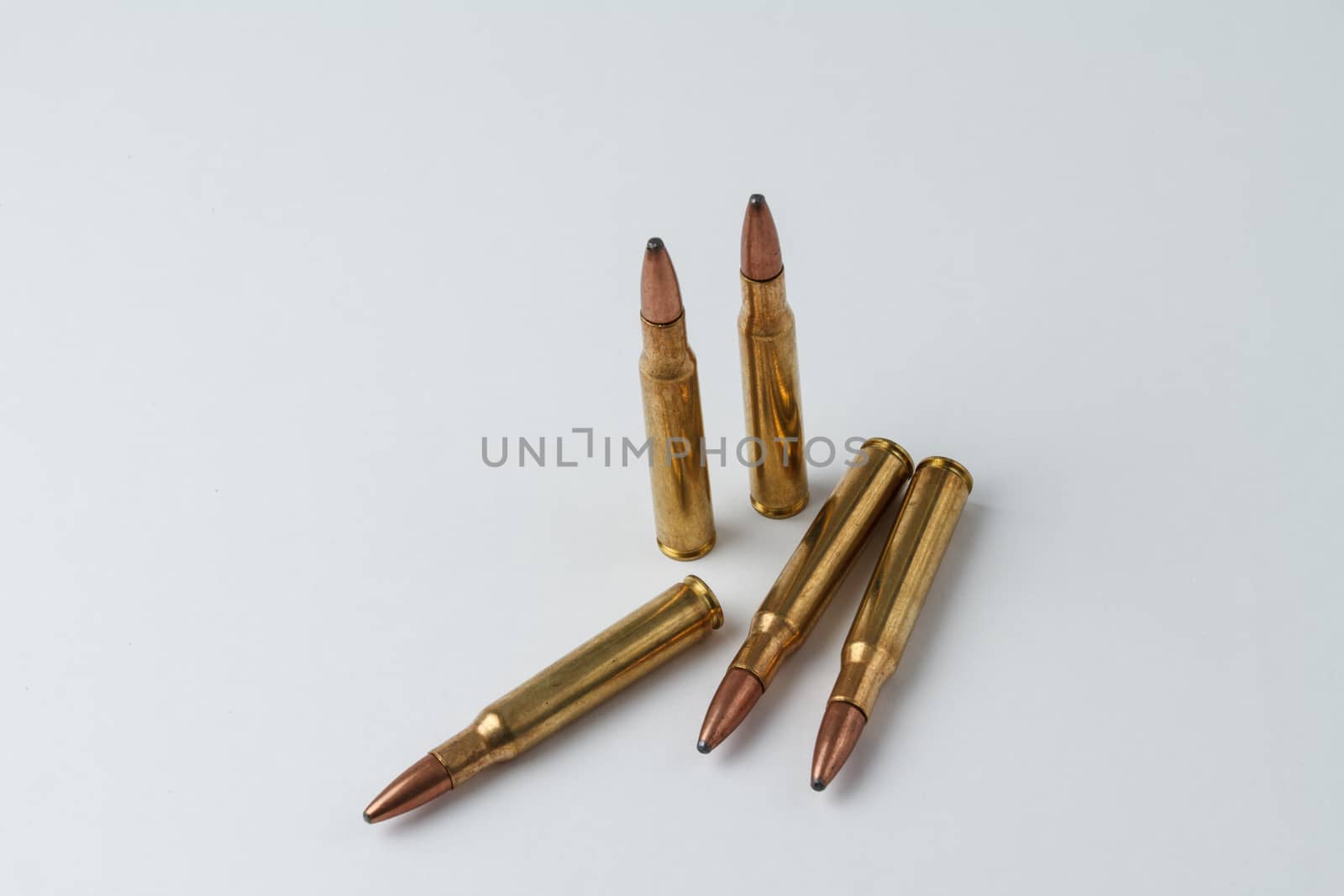 Five .30-06 caliber hunting rifle ammunition cartridges in a random arrangement