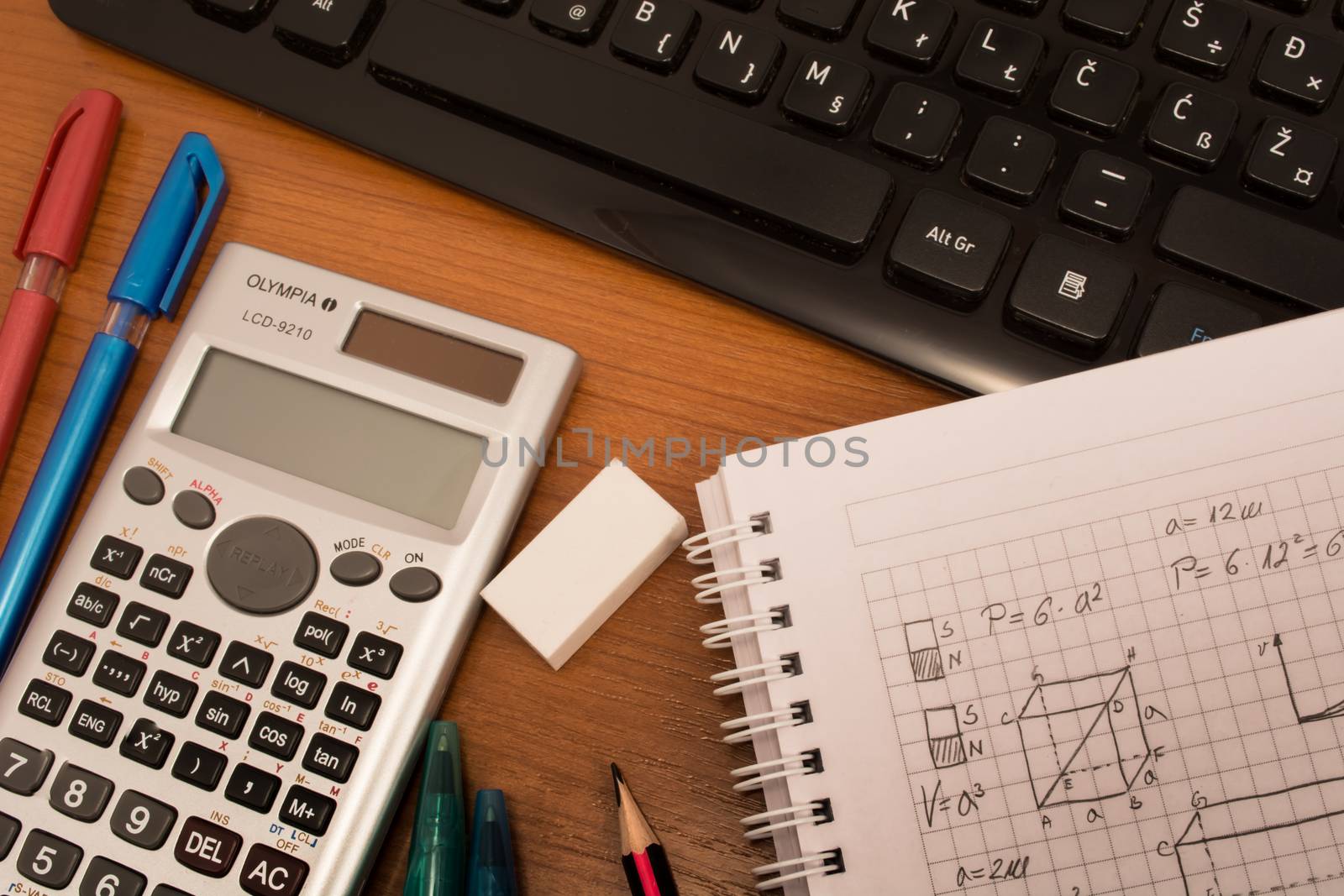 Computer keyboard, colorful pencils, eraser  and notebook on the table