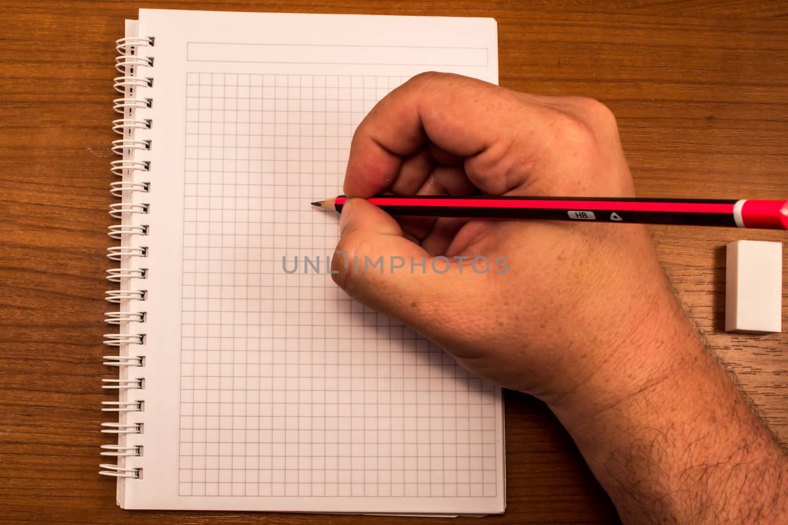 Male hand ready to write on empty notebook