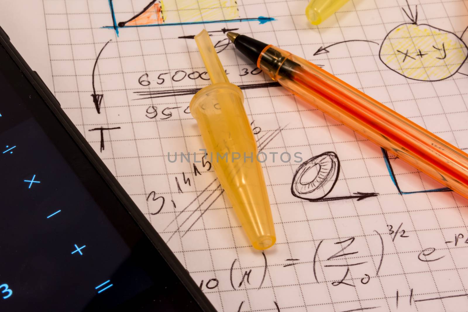 Notebook full of mathematics. Smart phone and pencils are visible