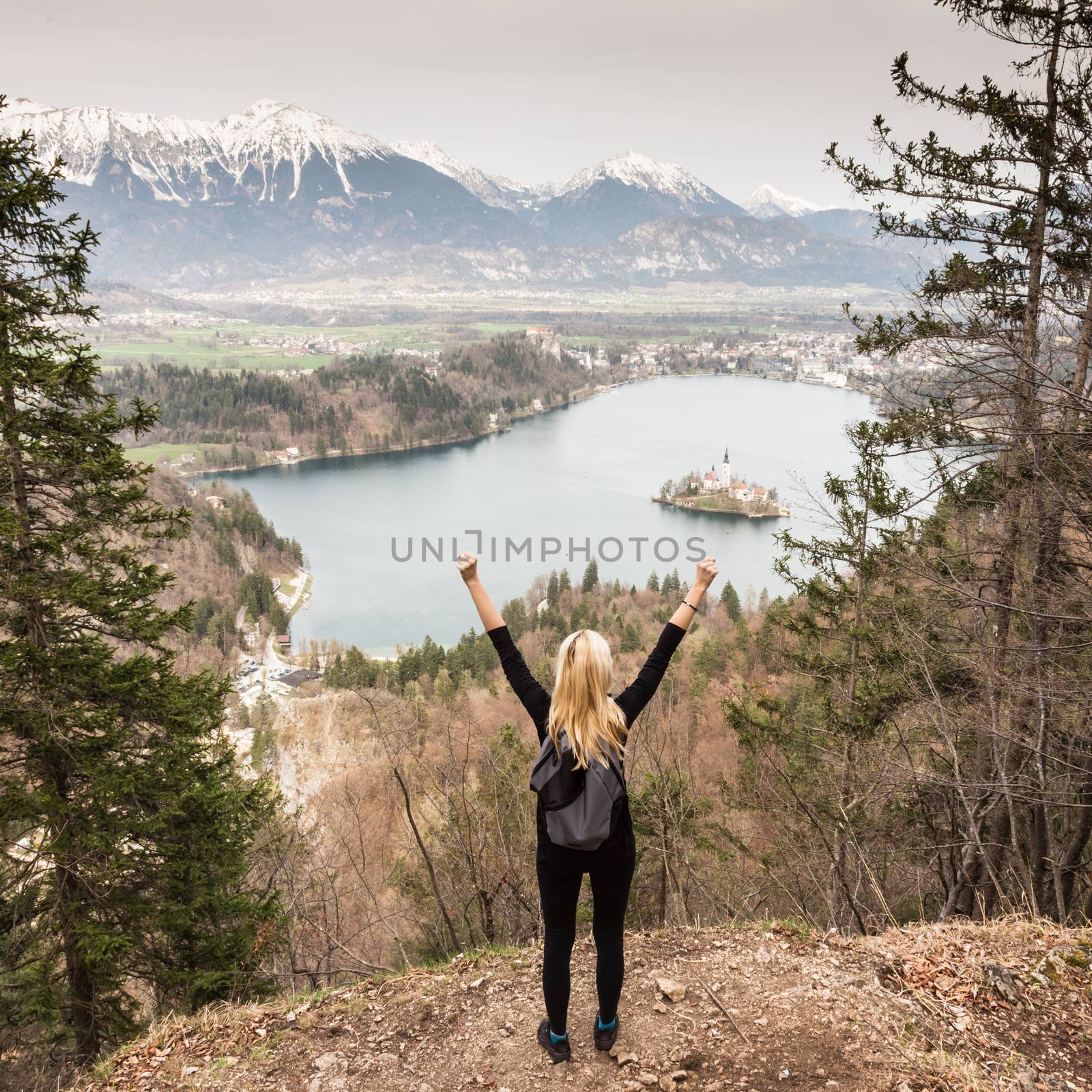 Made it. Young spoty active lady with hands rised admiring beautiful nature around Bled Lake in Julian Alps, Slovenia.