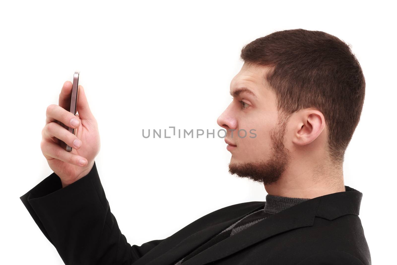 Businessman with a raised eyebrow using his phone screen isolated on white