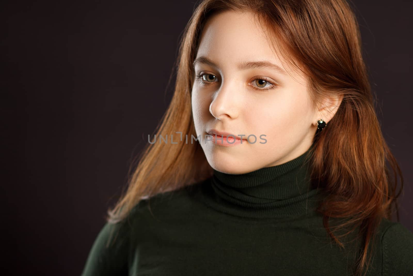 Closeup headshot portrait of redhead woman on dark background