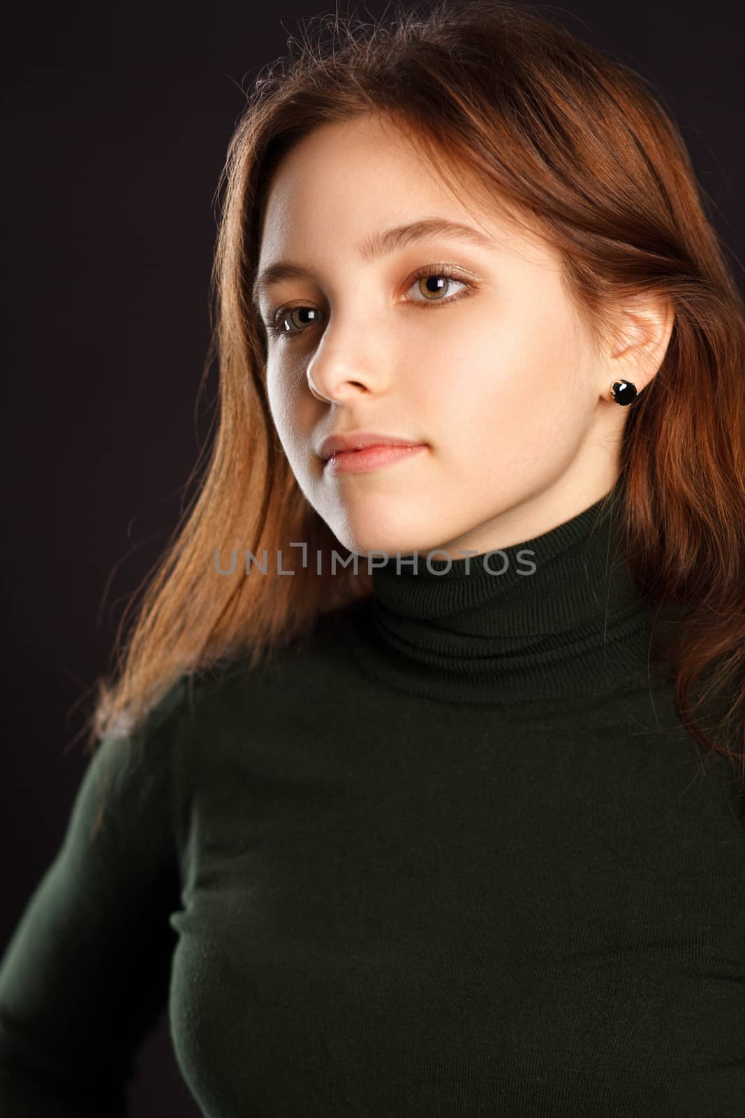 Closeup portrait of redhead woman on dark background