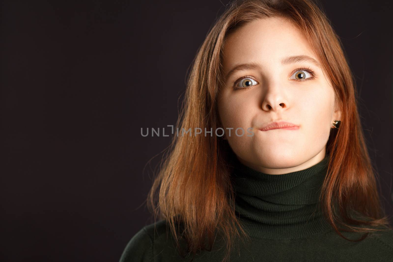 Closeup portrait of young redhead woman bites her lips in desire