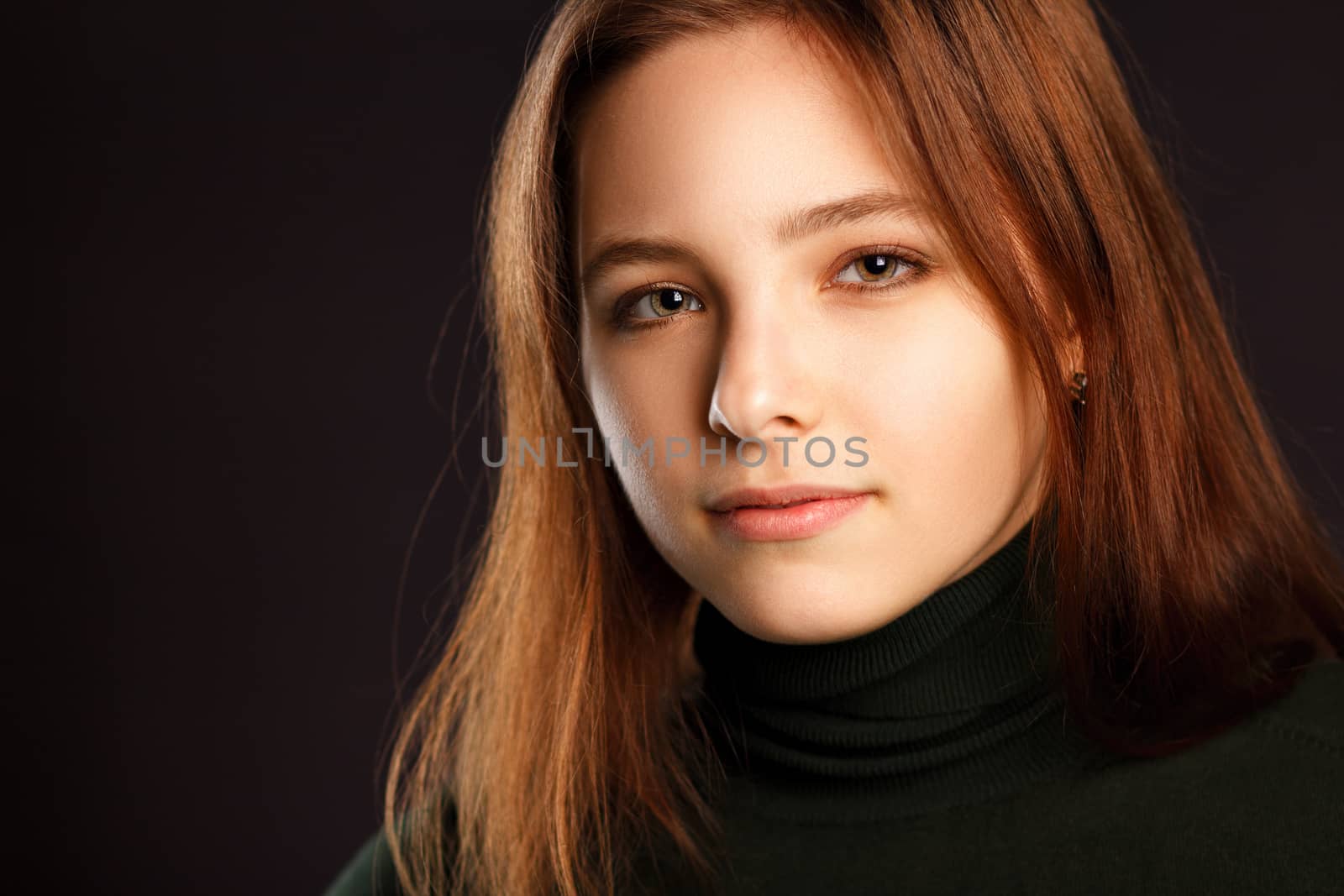 Closeup headshot portrait of redhead woman on dark background