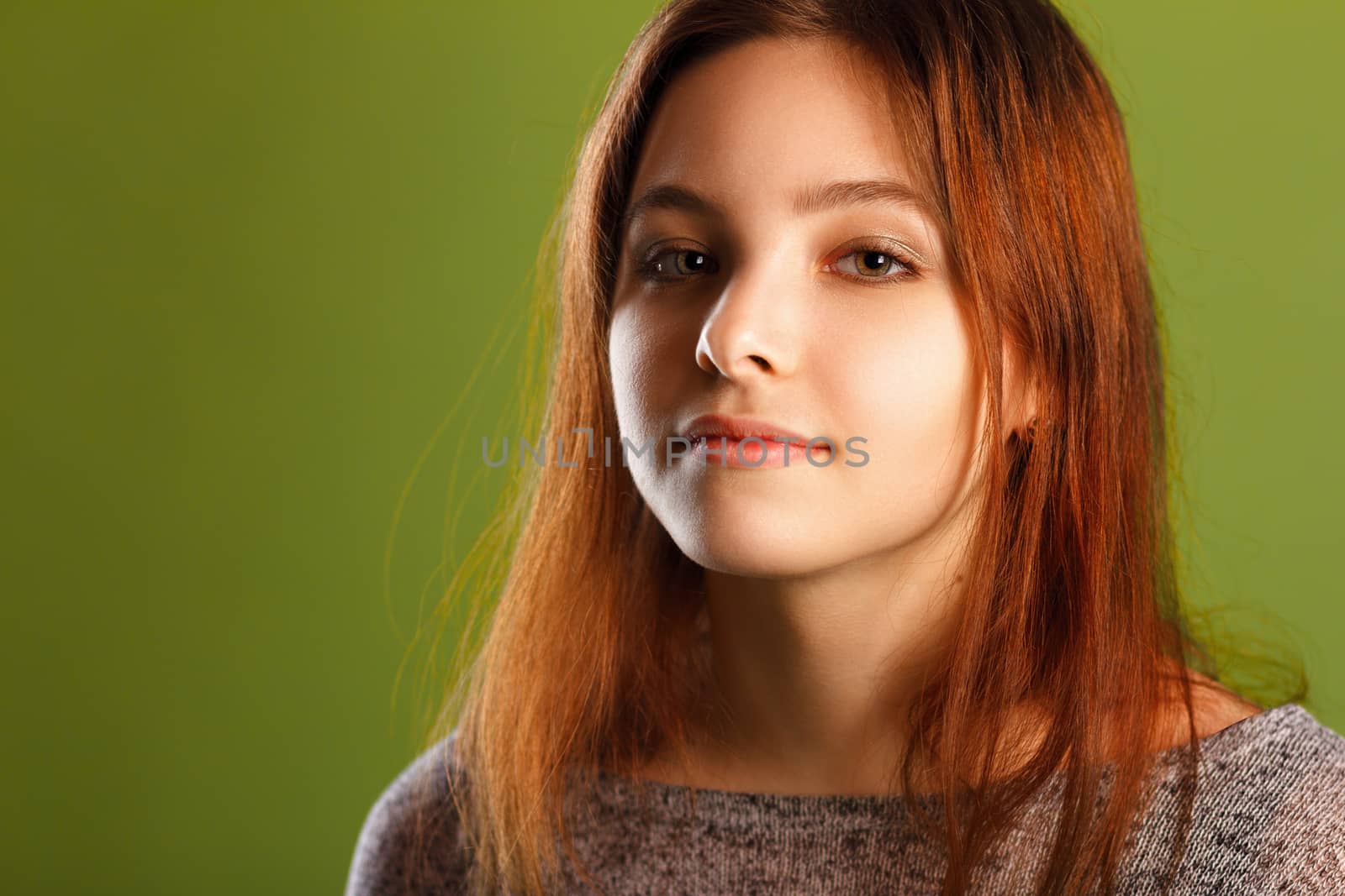 Portrait of young smiling girl on green