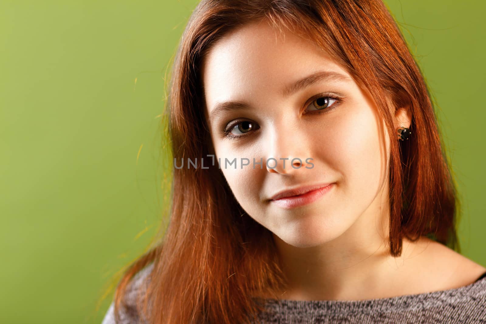Portrait of young smiling girl on green