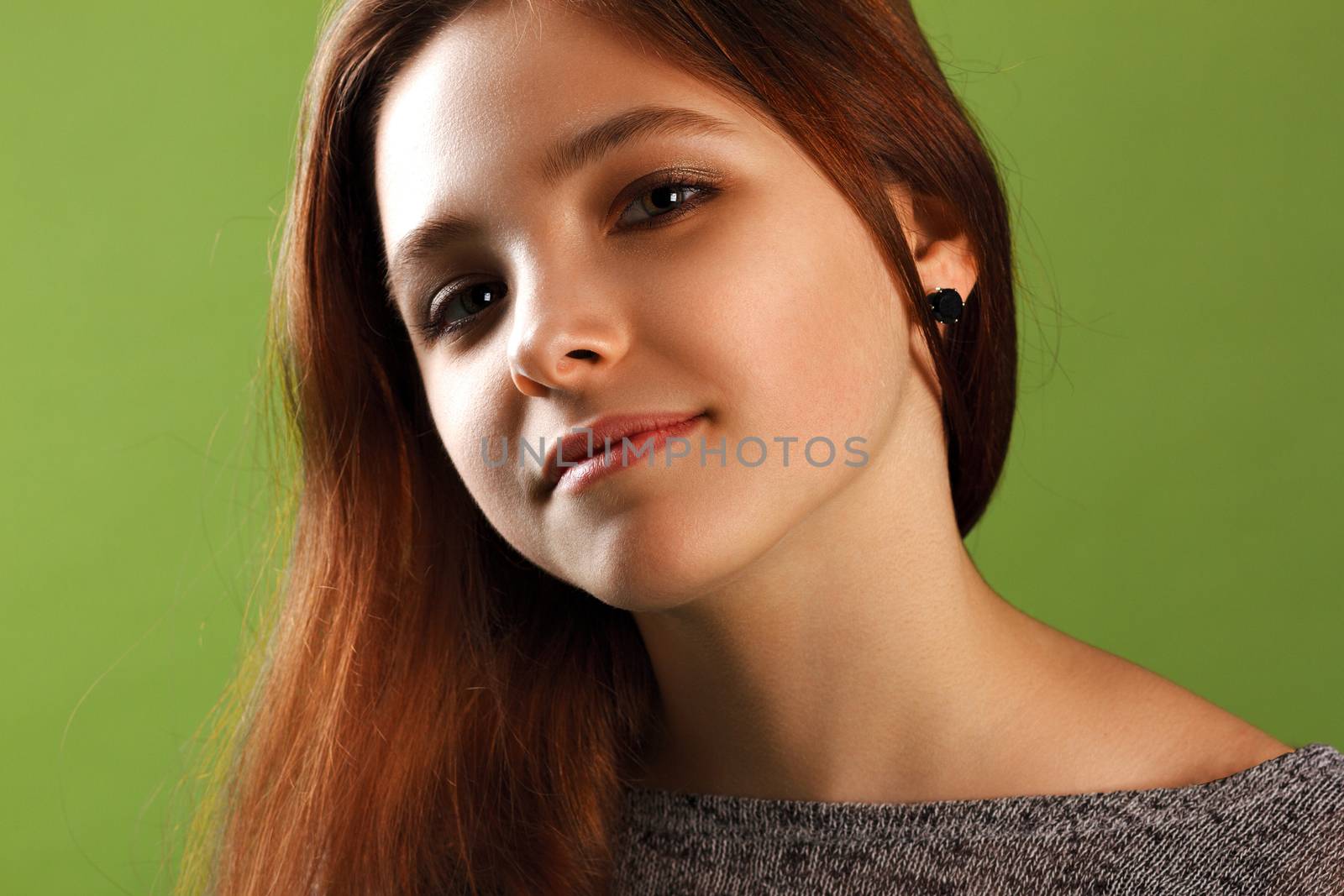 Portrait of young smiling girl on green